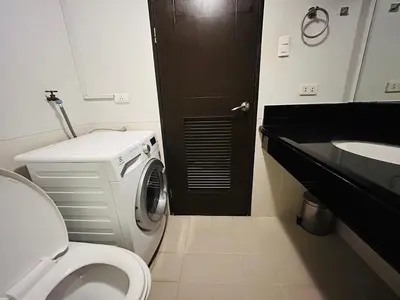 a bathroom with a toilet and a sink at The Mindful Home - 2BR Cozy Condo near NAIA in Manila