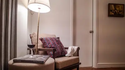 a room with a chair with a lamp and a wine glass at MiraNamin Nest LIRYO - Family Suite in Unique Historic Home with Indoor Plunge Pool, Garden Access, Self-Service Breakfast, Guest Kitchen in Manila
