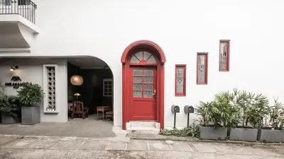 a red door on a white building with plants at MiraNamin Nest LIRYO - Family Suite in Unique Historic Home with Indoor Plunge Pool, Garden Access, Self-Service Breakfast, Guest Kitchen in Manila