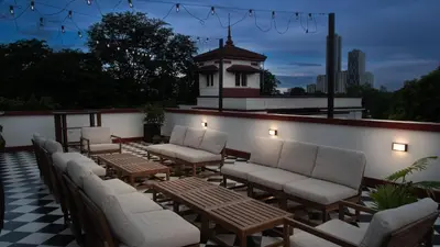 a row of chairs and tables on a patio at MiraNamin Nest LIRYO - Family Suite in Unique Historic Home with Indoor Plunge Pool, Garden Access, Self-Service Breakfast, Guest Kitchen in Manila