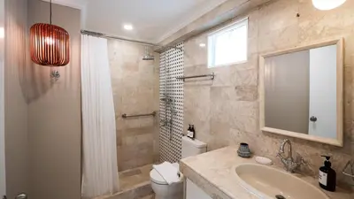 a bathroom with a sink and a shower and a toilet at MiraNamin Nest ROSAL - Garden View Suite in Unique Historic Estate with Indoor Plunge Pool, Self-Service Breakfast, Guest Kitchen in Manila