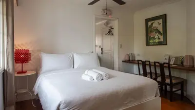 a bedroom with a white bed with towels on it at MiraNamin M A P I L I G - Private Suite in Historic Home with Unique View, Self-Service Breakfast, Indoor Plunge Pool, Rooftop, Shared Kitchen in Manila