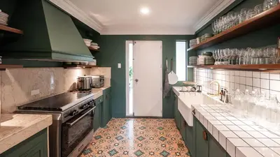 a kitchen with green cabinets and a stove top oven at MiraNamin M A P I L I G - Private Suite in Historic Home with Unique View, Self-Service Breakfast, Indoor Plunge Pool, Rooftop, Shared Kitchen in Manila