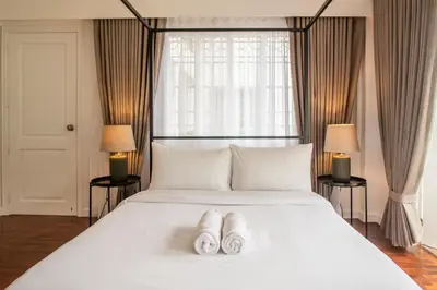 a bedroom with a large white bed with two white slippers at MiraNamin Nest GUMAMELA - Family Suite in Historic Home with Indoor Plunge Pool, Garden View, Pet-Friendly, Self-Service Breakfast in Manila