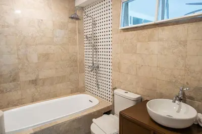 a bathroom with a tub and a sink and a toilet at MiraNamin Nest GUMAMELA - Family Suite in Historic Home with Indoor Plunge Pool, Garden View, Pet-Friendly, Self-Service Breakfast in Manila