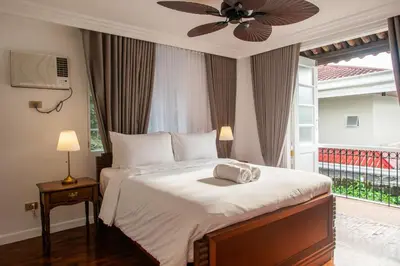 a bedroom with a bed with a ceiling fan at MiraNamin SAMPAGUITA - Two Bedroom Suite in Historic Home with Indoor Plunge Pool, Self-Service Breakfast, Garden View, Pet-Friendly in Manila