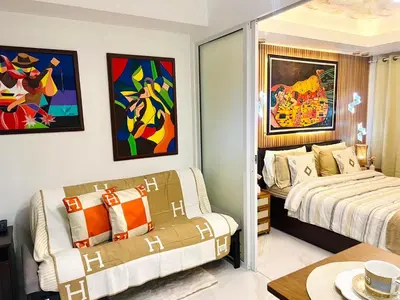 a bedroom with two beds and paintings on the wall at Paris Hilton Beach Resort in Manila