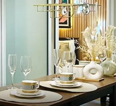 a table with two plates and glasses and a chandelier at Paris Hilton Beach Resort in Manila