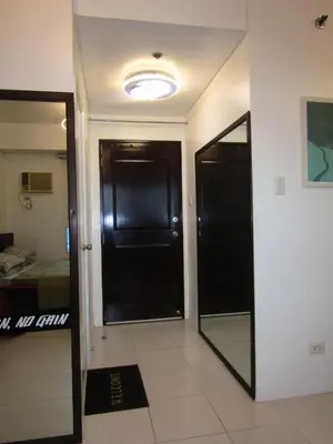 a hallway with a black door and a mirror at SM MEZZA 1 RESIDENCES Studio Room Gian Thyresse Crib in Manila