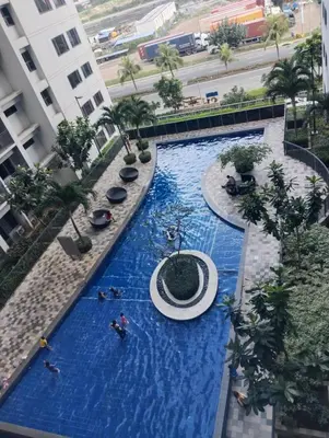 a pool in a building with people swimming in it at Casiana Place Staycation at Shore2 Residences in Manila