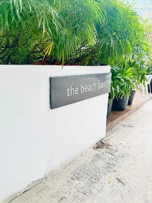 a sign that reads the beach bar on a white wall at We Vibe, Azure Urban Resort Residences in Manila