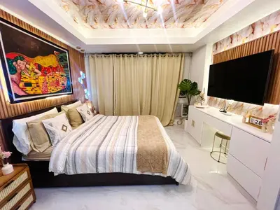 a bedroom with a large bed and a television at Miami Suites in Manila