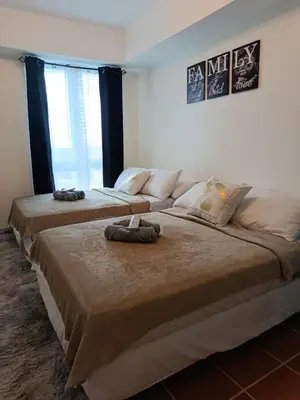 two large beds in a room with two large windows at Urban Metro Escape in Pasig City in Manila