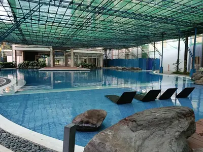 a large swimming pool with chairs in a building at Urban Metro Escape in Pasig City in Manila
