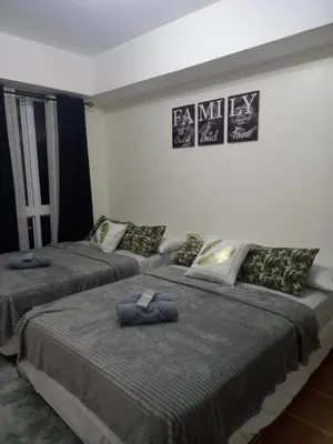 two beds sitting next to each other in a bedroom at Urban Metro Escape in Pasig City in Manila