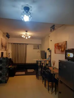 a living room with a couch and a table with chairs at Urban Metro Escape in Pasig City in Manila
