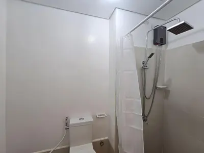 a white bathroom with a shower and a toilet at 1BR Condotel with Balcony at SM Light Residences #LT12 in Manila