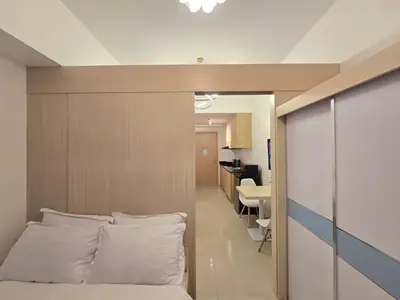 a bedroom with a bed with white pillows at 1BR Condotel with Balcony at SM Light Residences #LT12 in Manila