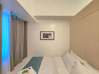 a small bedroom with a bed and a window at 1BR Condotel with Balcony at SM Light Residences #LT12 in Manila