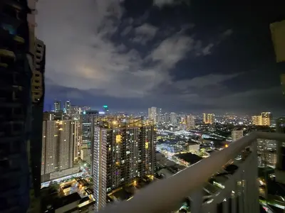 a view of a city skyline at night at 1BR Condotel with Balcony at SM Light Residences #LT13 in Manila