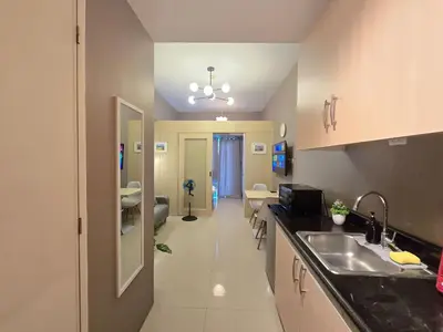 a kitchen with a sink and a living room at 1BR Condotel with Balcony at SM Light Residences #LT13 in Manila