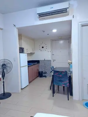 a kitchen with a table and a white refrigerator at Jennie's Lucky 5M Suite in Manila