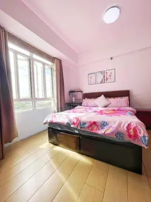 a bedroom with a large bed with pink sheets at Jennie's Lucky 5M Suite in Manila