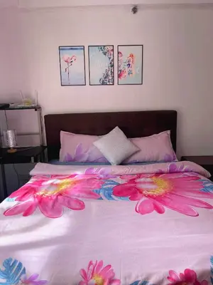 a bed with pink flowers on it in a bedroom at Jennie's Lucky 5M Suite in Manila