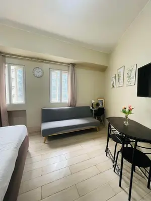 a living room with a couch and a table at Jennie's Lucky 5M Suite in Manila