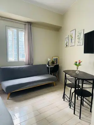 a living room with a blue couch and a table at Jennie's Lucky 5M Suite in Manila