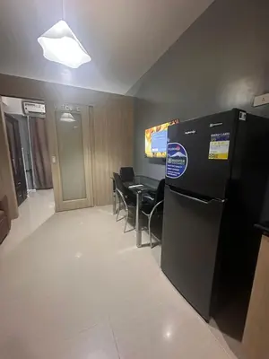 a room with a table and chairs and a refrigerator at Shore Residences Cozy oasis by Richnells Tower D in Manila