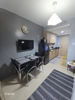 a living room with a table and chairs and a kitchen at Shore Residences Cozy oasis by Richnells Tower D in Manila