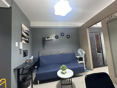 a living room with a blue couch and a table at Shore Residences, Vintage charm by Richnells Tower D in Manila