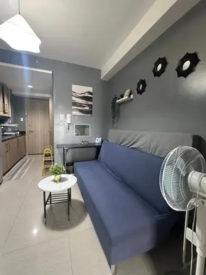 a living room with a blue couch and a kitchen at Shore Residences, Vintage charm by Richnells Tower D in Manila