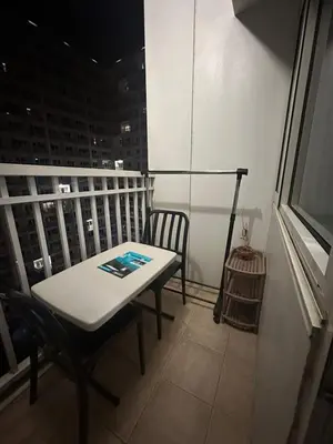 a table and chairs on a balcony with a window at Shore Residences, Vintage charm by Richnells Tower D in Manila