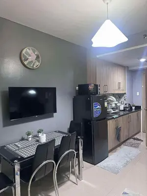 a kitchen and a dining room with a table and chairs at Shore Residences, Vintage charm by Richnells Tower D in Manila
