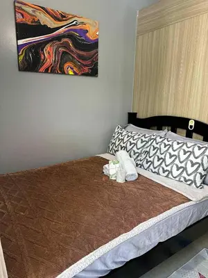 a bedroom with a bed with a painting on the wall at Shore Residences, Vintage charm by Richnells Tower D in Manila