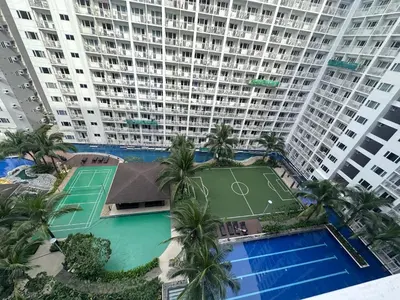 an aerial view of a tennis court in front of a large building at Shore Residences, Vintage charm by Richnells Tower D in Manila