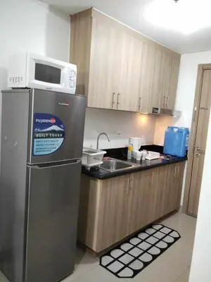 a kitchen with a microwave on top of a refrigerator at VSV Luxury Family suits Moa staycation in Manila