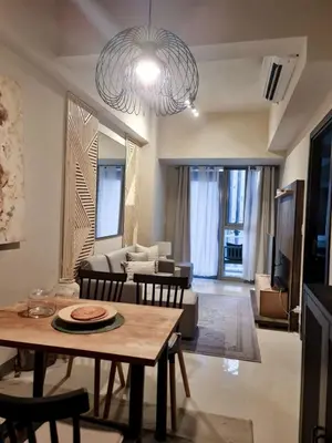 a living room with a table and a couch at LuxeStaysMnl Cozy Japandi Netflx Pool 400mbps in Manila
