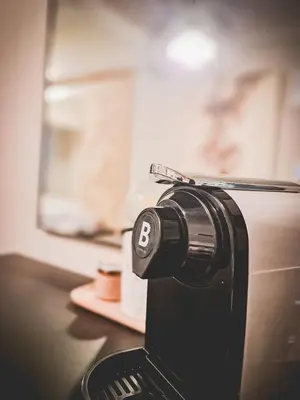 a close up of a toaster with the letter b on it at LuxeStaysMnl Cozy Japandi Netflx Pool 400mbps in Manila