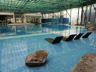 a swimming pool with chairs in a building at Spacious Staycation in Pasig Urban Metro Escape in Manila