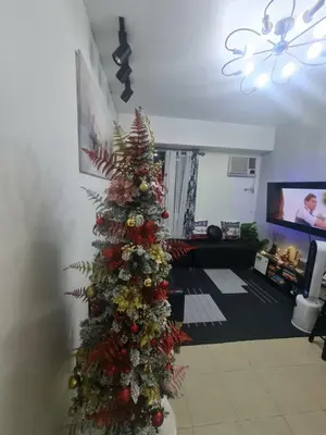 a christmas tree in the middle of a living room at Spacious Staycation in Pasig Urban Metro Escape in Manila