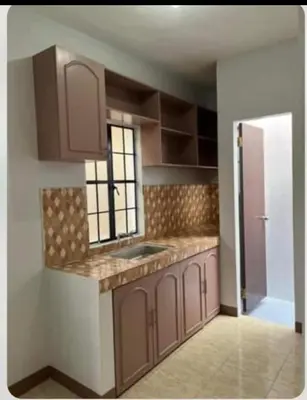 a kitchen with brown cabinets and a sink at Laureano di trevi tower 2 Condominium Corporation in Manila