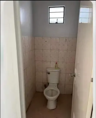 a bathroom with a toilet and a window in it at Laureano di trevi tower 2 Condominium Corporation in Manila