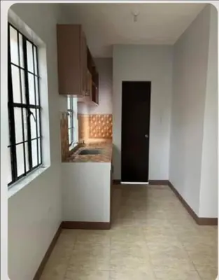 a kitchen with white walls and a black door at Laureano di trevi tower 2 Condominium Corporation in Manila
