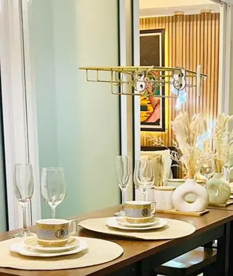 a dining room table with glasses and plates and a chandelier at Miami suites in Manila