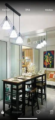 a dining room with a table with chairs and lights at Miami suites in Manila