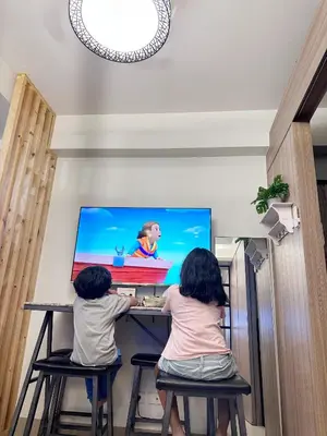 two children sitting at a table playing a video game at 1573 Budget Condo near MOA and Airport in Manila