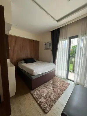 a bedroom with a bed and a large window at Chelsea Tower 3 in Manila